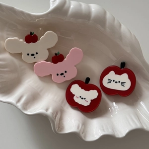Détail de barrettes mignonnes en forme de chien et pomme sur un plateau coquillage