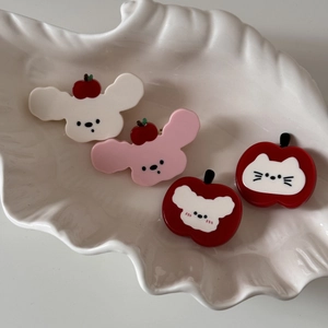 Détail des pinces à cheveux mignonnes en acétate avec chat et pomme sur plateau