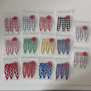 14 sets of patterned snap clips with colorful plaid and polka dots in clear bags