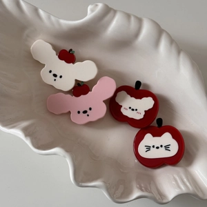 Lot de barrettes mignonnes en acétate avec chiens et pommes sur un plat blanc