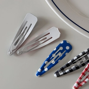Detail view of colorful snap clips featuring plaid patterns and solid color finish