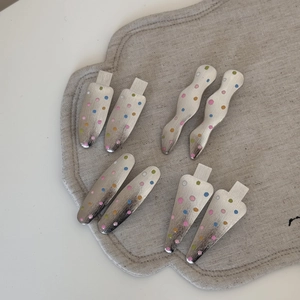 Detail von Haarspangen aus gebürstetem Silbermetall mit bunten bunten Polka-Dots Verzierten