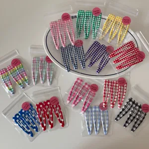 Detail of colorful gingham and polka dot snap hair clips set in transparent packaging