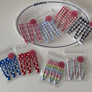 Detailed view of printed plaid and polka dot BB hair clips in stylish zipper bag
