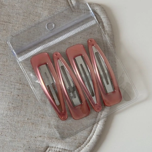 Close-up of four vintage pink marble BB hair clips in square and teardrop shapes
