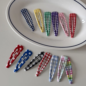 Colorful set of 13 floral and polka dot pattern BB hair clips for women in a white tray