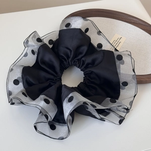 Detail of black satin scrunchie with silver polka dot organza trim and ruffled edges