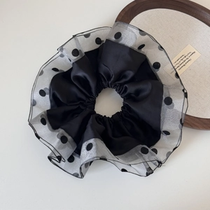 Detail of large black satin scrunchie with grey polka dot organza trim and layered ruffles