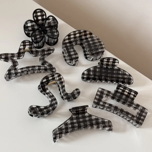 Sept pinces à cheveux à carreaux noir et blanc de formes géométriques variées