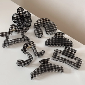Détail du lot de 7 pièces montrant des motifs à carreaux noirs et blancs sur diverses pinces