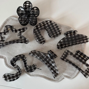 Collection détaillée de sept pinces à cheveux à damier noir et blanc aux formes variées