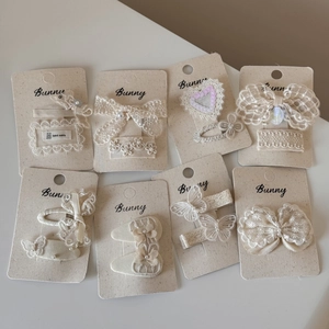 Off-white French vintage lace bow hair clip set with pearls and sequins on display cards