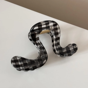 Détail d'une pince à cheveux à carreaux avec design ondulé et fini transparent