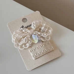 Detail of cream white lace bow hair clip and rectangular barrette set with oval bead