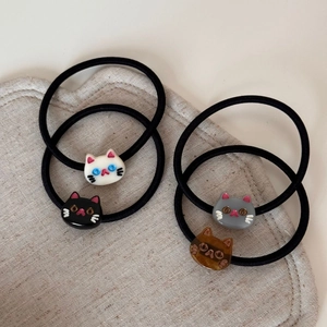 Detail of four colorful resin cat head hair ties on high-elastic black rubber bands
