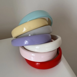 Macro detail of thick glossy patent leather headbands in multiple candy colors