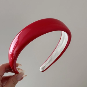 Detail view of the red glossy patent leather sponge headband with non-slip inner fabric
