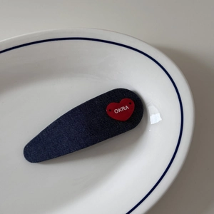 Vue détaillée de la barrette en denim bleu foncé avec un accent de cœur rouge