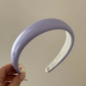 Close-up of lavender glossy patent leather headband with thick sponge and white fabric lining