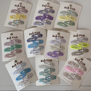 Flat lay of minimalist BB hair clips set featuring plaid and floral fabric patterns