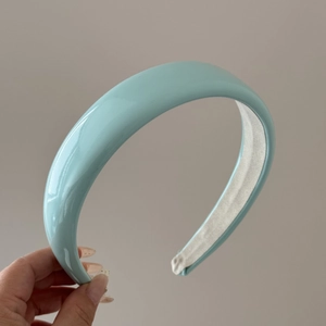 Detail view of light blue glossy patent leather sponge headband with smooth fabric lining