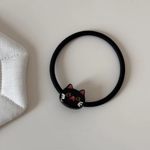 Close-up of black elastic hair tie with a cute 3D resin cat head charm for girls