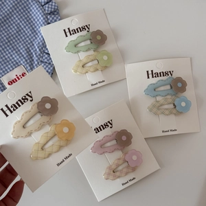 Close-up of cute floral hair clips set on card packaging with pastel colors and flower design