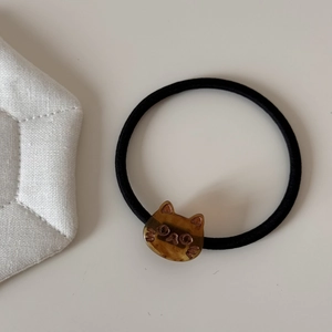 Detail of high-elastic black hair tie with a brown translucent acrylic cat head charm
