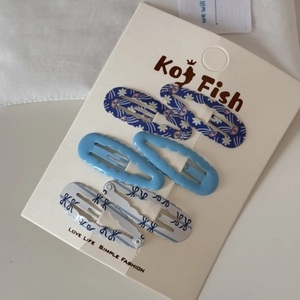Detail showing 6-piece blue wave and floral print metal hair clips on display card