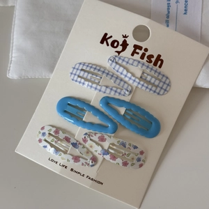 Detail of 6-piece hair clip set featuring blue plaid, solid color, and floral wave patterns