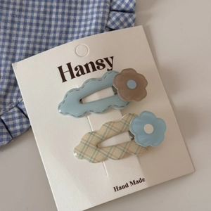 Detail of cute flower hair clips in blue and checkered patterns on a display card