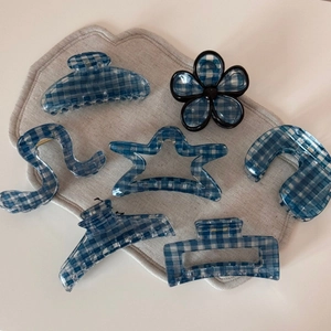 7-piece set of blue gingham hair claws in diverse shapes on beige fabric background