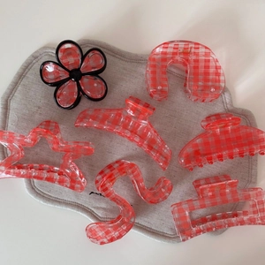 Detailed set of six red and white checkered acrylic hair claws in various shapes