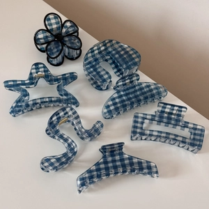 Macro view of blue gingham pattern hair claws in various geometric resin shapes