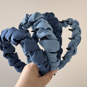 Detail of three denim fabric headbands with anti-slip inner teeth and pleated texture