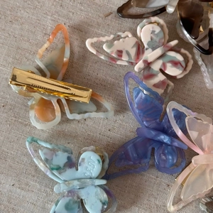 Detailed close-up of butterfly hair clips in colorful acetate with golden metal clips