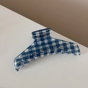 Detailed view of blue and white gingham hair claw clip with glossy finish