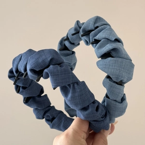 Detail view of denim blue braided headbands with non-slip teeth and cloud bubble texture