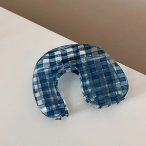 Macro view of blue gingham checkered hair claw clip in translucent acrylic material