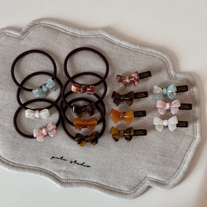 Gros plan de barrettes et chouchous nœuds en acétate aux motifs écaillés et nacrés