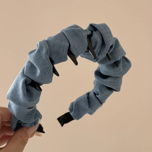 Detail showing non-slip black inner teeth on textured blue-gray fabric headband
