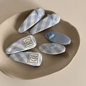 Detail of 6-piece blue and white checkered hair clips with cute dog embroidery and bows