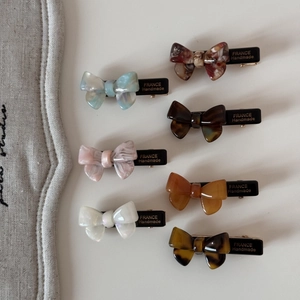 Détail de 7 barrettes à nœuds en acétate de diverses couleurs, dont marbre et écaille de tortue