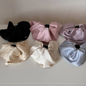 Detail view of large satin hair clips in six elegant colors with silk texture