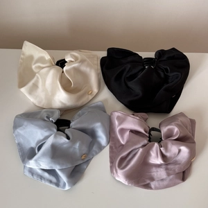 Four elegant satin hair claws in white, black, blue, and pink with gold button detail