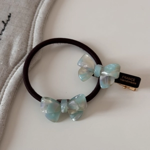 Détail du chouchou et de la barrette avec nœud bleu iridescent et texte doré France