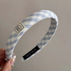 Detailed macro view of the handmade blue gingham fabric headband with a cute dog patch