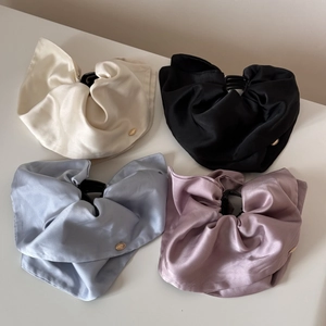 Satin scrunchies set in cream, black, blue, and pink with elegant gold logo details