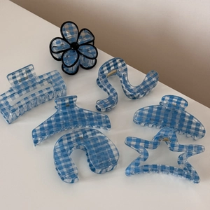 Detail view of light blue checkered hair claws in various shapes for elegant styling