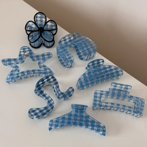 Flat lay of blue gingham hair clips in various shapes like star and flower patterns